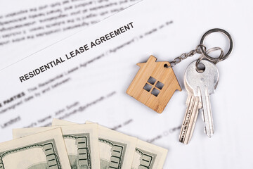 Rental or Residential Lease agreement contract, magnifying glass, dollar money cash, and house keys. Short and long term rentals, housing searching crisis, signing lease agreement, and rising prices.