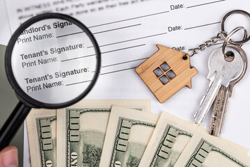 Rental or Residential Lease agreement contract, magnifying glass, dollar money cash, and house keys. Short and long term rentals, housing searching crisis, signing lease agreement, and rising prices.
