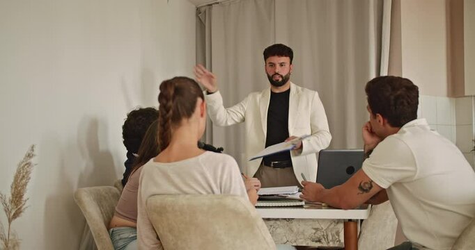 Students listen attentively as their professor explains concepts during private tutoring at home. They prepare for an exam in a focused and collaborative atmosphere.