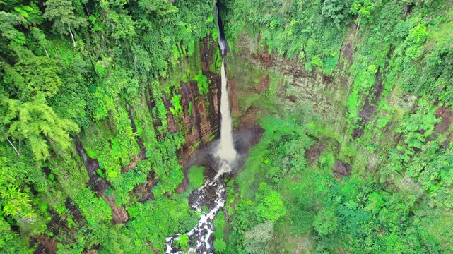High angle drone aerial view of Biru waterfall and jungle in East Java, Indonesia