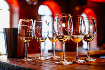 Golden Reflections: A Collection of Elegant Glasses Filled with Crisp White Wine, Capturing Moments of Celebration and Togetherness.