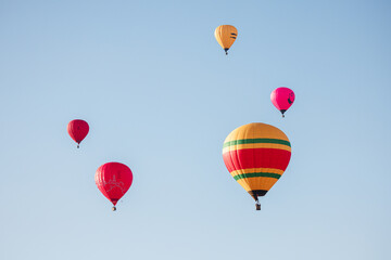 A Symphony in the Sky: Colorful Hot Air Balloons Dancing Among the Clouds at Sunrise.