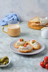 Cold appetizer, mackerel rillettes on white bread toasts on ceramic plate on gray concrete background. Recipes fish, seafood.