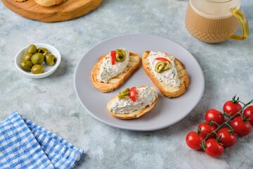 Cold appetizer, mackerel rillettes on white bread toasts on ceramic plate on gray concrete...
