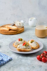 Cold appetizer, mackerel rillettes on white bread toasts on ceramic plate on gray concrete background. Recipes fish, seafood.