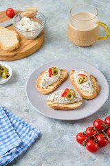 Cold appetizer, mackerel rillettes on white bread toasts on ceramic plate on gray concrete background. Recipes fish, seafood.