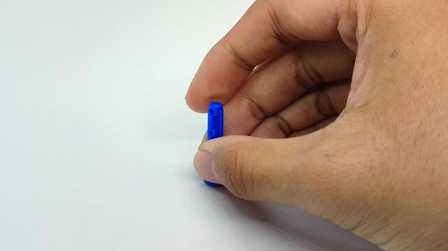 Dispose of the blood lancet needle by inserting it into the needle cap on the white background