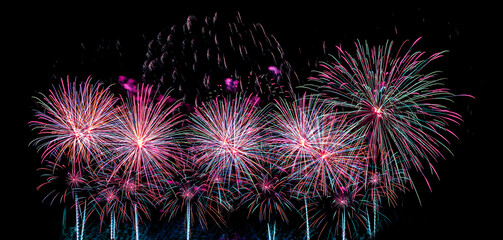 Colorful celebration fireworks isolated on a black sky background.