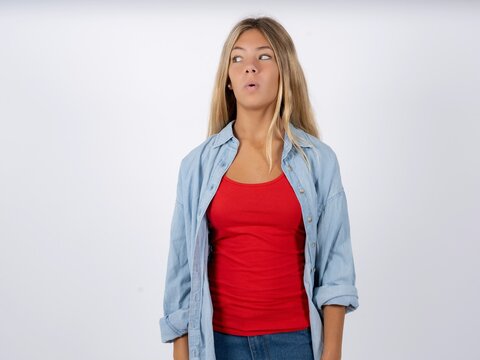 Shocked Beautiful teen girl wearing denim jacket look empty space with open mouth screaming: Oh My God! I can't believe this.