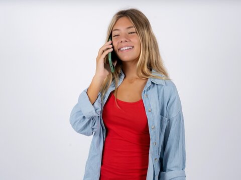 Happy joyful charming Beautiful teen girl wearing denim jacket talk speak phone smile good mood