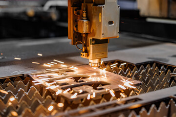 Precision Sparks: A laser cutting machine meticulously crafts intricate designs on gleaming metal,...