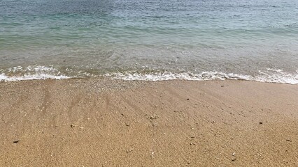 Small waves on a beach, Tiny waves lapped at the shore. Gentle ripples danced across the calm, shallow water. Kondang Merak Beach in Malang Indonesia