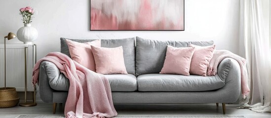 Modern living room with grey and pink decor against an abstract white wall poster.