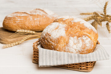 Freshly baked bread on basket against natural background. Perspective view bread copy space