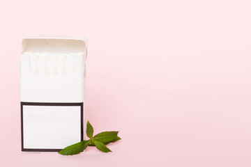 Pack of menthol cigarettes and fresh mint on colored table, Menthol cigarettes top view flat lay
