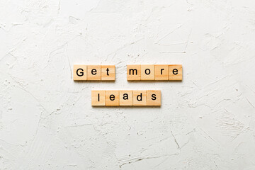 Get more leads word written on wood block. Get more leads text on table, concept