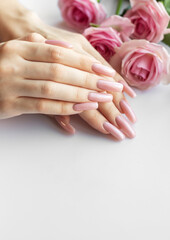 Fototapeta premium Woman showing her manicure with pink nail polish and roses