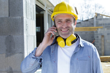construction worker on the phone with noise cancelling earphones