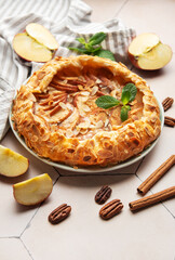 Delicious homemade apple galette decorated with almond flakes and fresh mint