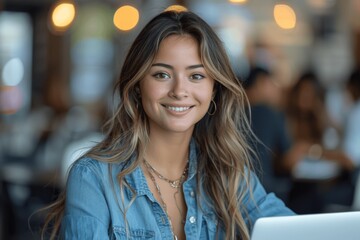 Obraz premium Smiling middle-aged businesswoman working on laptop in modern office
