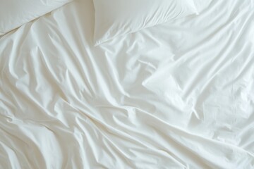 Top view of unmade bed with white wrinkled sheets and pillow