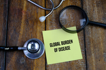 GLOBAL BURDEN OF DISEASE words on yellow memo pad magnifying glass and stethoscope. Medical concept. 