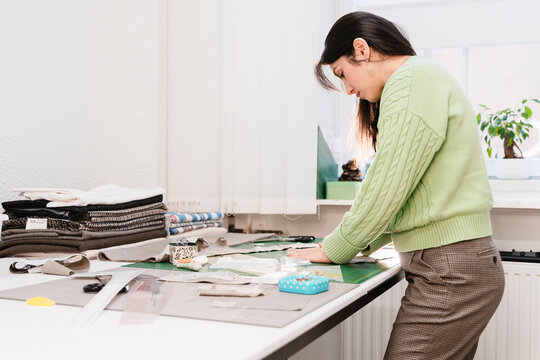 Mature tailor working on design at table in workshop