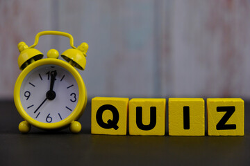 the words Quiz Time beside mini alarm clock on a plain background. the concept of answering quizzes...