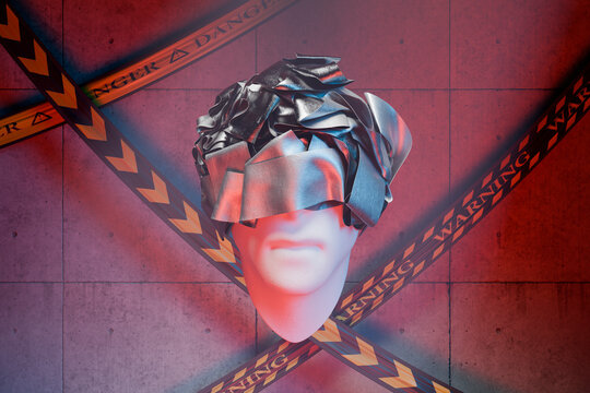 Mannequin head with silver foil in front of warning tapes
