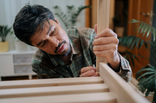Mature man assembling furniture at home