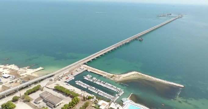 Aerial view of a long pier on the Mediterranean Sea.