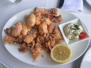 Fried shrimps with white tartar sauce and lemon slice served at restaurant.