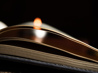 Open book with candle light bokeh background