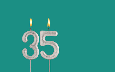 Birthday card on a green background - Candle in the shape of the number 35