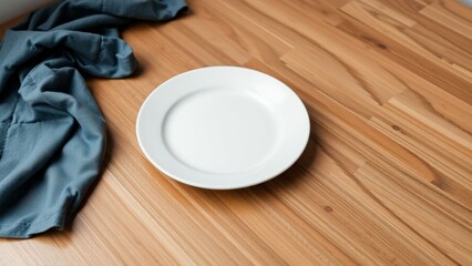 Minimalist Kitchen Essentials: Simple White Plate on Rustic Wooden Table with Blue Cloth for Cozy Dining