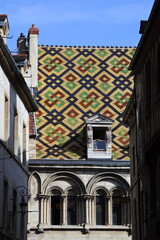 Blauer Himmel und farbige Dachziegel auf einem Hausdach in Dijon	