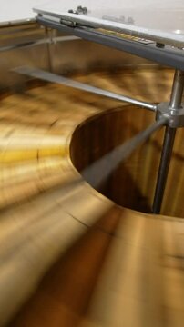 Getting the fresh healthy organic honey from the honeycombs. Switched on electric honey extracting machine with open lid close up. Vertical video