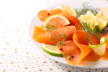 smoked salmon slices on plate with lemon and dill
