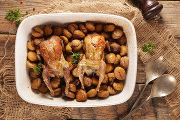 Whole roasted quail with chestnut on wooden table