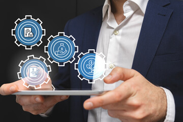 Businessman using tablet with business and finance icons on the screen.