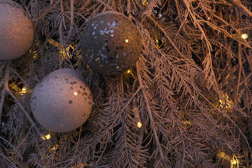 New Year's toy. Decorated Christmas tree on a blurry, sparkling and fabulous background. Garland and bokeh.