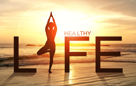 Silhouette of A woman practicing Yoga vrikshasana tree pose on tropical beach with sunrise sea and sky background, watching sunset, standing as a part of the wording life, concept for healthy life.