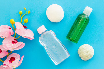 Facial toner in a bottles with flower, top view. Cosmetic products for face cleansing and...