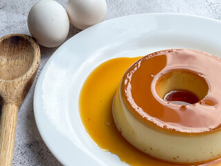 Delicious milk pudding with caramel glaze on a white plate.