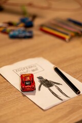 Fototapeta premium Drawing of Enderman from Minecraft drawing and red Mattel Lightning McQueen toy car on a table