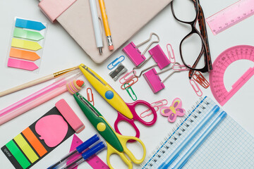 A vibrant collection of office and school supplies, including scissors, pens, sticky notes, paper...