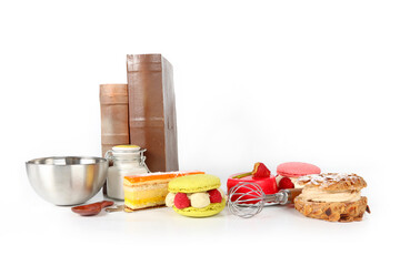Assortment of cakes with kitchen utensils on a white background