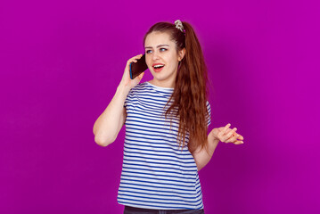 Charming Young Woman talking on Smartphone, Sharing Exciting News with Friends or Family, Engages in a Heartwarming Conversation. Standing against a bright colorful background