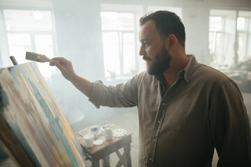 Focused male painter working on a new artwork