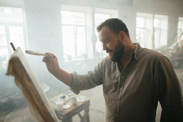 Focused male painter working on a new artwork
